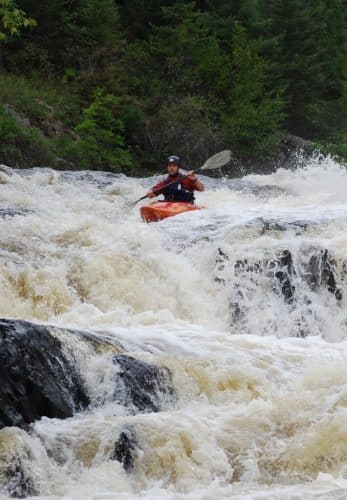 Mick Lautt white-water kayaking over turbulent rapids